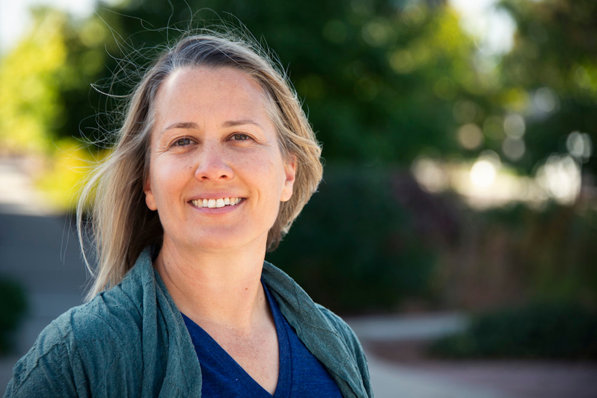 Natalie, life coach, smiling outdoors in warm afternoon light